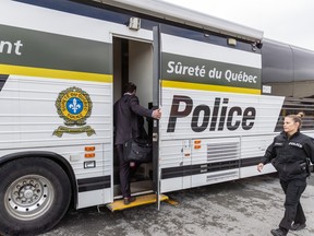 A Surete du Quebec command bus with a police officer walking past.