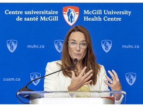 A woman speaks at a podium in front of the insignia for the McGill University Health Centre