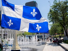 A Quebec flag flaps in the wind at a walk- through installation to celebrate Saint-Jean-Baptiste Day in Montreal on June 24, 2021.