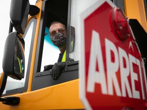 A man looks out the driver's window of a school bus