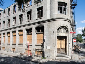 An old three-storey building with boarded-up windows and fire damage