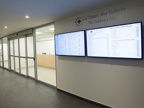 A sign on a wall in a hallway reads 'La Clinique pour Enfants/The Children's Clinic'