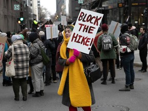 A protester holds a sign reading Block the Hike in the foreground of a rally against raised tuition rates.