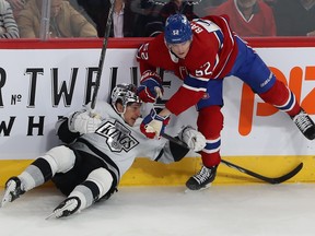 Canadiens' Justin Barron balances on his right skate while his stick is lowered atop Kings’ Trevor Moore, who was pushed onto his backside during game last month at the Bell Centre.