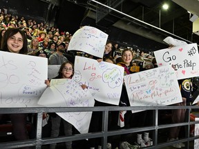 Fans hold up homemade posters cheering on Ottawa and Montreal's Marie-Philip Poulin
