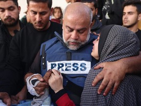 Al Jazeera's bureau chief in Gaza, Wael Al-Dahdouh (C), hugs his daughter during the funeral of his son Hamza Wael Dahdouh.
