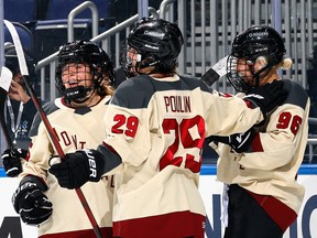 Three Montreal PWHL players celebrate on the ice