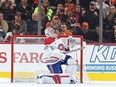 Cayden Primeau looks up while on one knee in the goal crease as Flyers fans celebrate behind him