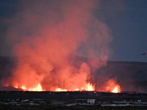 A helicopter flies near lava explosions and smoke near residential buildings in the southwestern Icelandic town of Grindavik after a volcanic eruption on Sunday, Jan. 14, 2024. Seismic activity had intensified overnight and residents of Grindavik were evacuated, Icelandic public broadcaster RUV reported. This is Iceland's fifth volcanic eruption in two years, the previous one occurring on Dec. 18, 2023, in the same region southwest of the capital Reykjavik. Iceland is home to 33 active volcano systems, the highest number in Europe.
