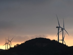 Wind turbines are seen at sunset
