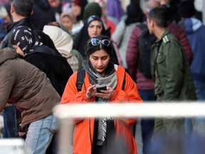 An Iranian woman checks her phone on a street in Tehran on Jan. 18, 2024.