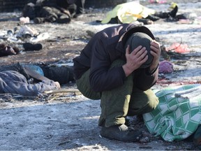 A man cries next to a body of his wife killed as a result of a missile strike in Donetsk on Sunday, Jan. 21, 2024, amid the continuing Russian-Ukrainian conflict.