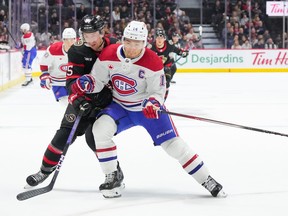 A Canadiens and Senators player rub shoulders as they fight for position on the ice