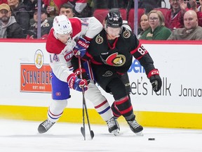 Nick Suzuki #14 of the Montreal Canadiens and Jake Sanderson #85 of the Ottawa Senators battle for the puck during the first period at Canadian Tire Centre on January 18, 2024 in Ottawa, Ontario, Canada.