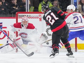 The puck is in the net behind Canadiens' Cayden Primeau as Senators' Mathieu Joseph follows through on his shot