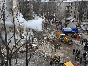 Ukrainian rescue workers clear debris at the site of a missile attack in Kharkiv on Jan. 23, 2024.