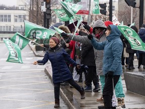 Health-care workers protest on a street corner in Montreal.