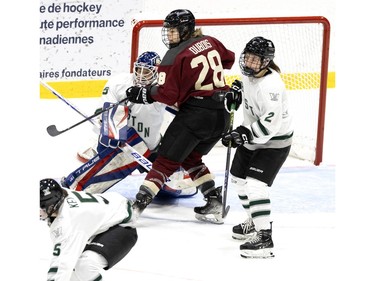 Montreal Catherine Dubois (28) looks for a pass as she parks in front of Boston Cami Kronish (35) during the PWHL home opener at the Verdun Auditorium in Montreal on Saturday, Jan. 13, 2024. Boston Emily Brown (2) is also seen.