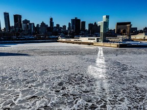 A ray of sun over a partially frozen body of water with a skyline in the background.