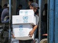 A Palestinian man carries boxes of food outside an aid distribution centre run by the United Nations Relief and Works Agency (UNRWA) at the Bureij refugee camp in the Gaza Strip in July 2019.