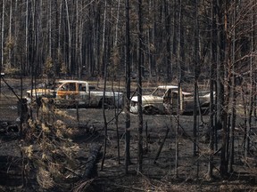 Burnt-out trucks from a wildfire sit on a property near Drayton Valley, Alta., Wednesday, May 10, 2023.