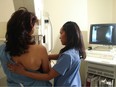 A technician with a patient doing a mammogram