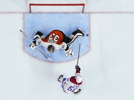 a photo taken from directly above the goal crease shows the puck going wide next to the flyers goalkeeper's skate.