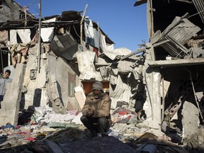 Palestinians look at the destruction after an Israeli strike in Rafah, southern Gaza Strip, Thursday, Jan. 18, 2024.