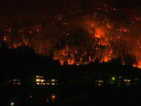 The McDougall Creek wildfire burns on the mountainside above houses in West Kelowna, B.C., Friday, Aug. 18, 2023.