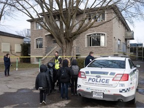 A police vehicle outside a two-storey home with yellow caution tape.