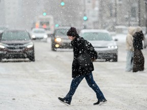 A person crosses the street during a snow storm