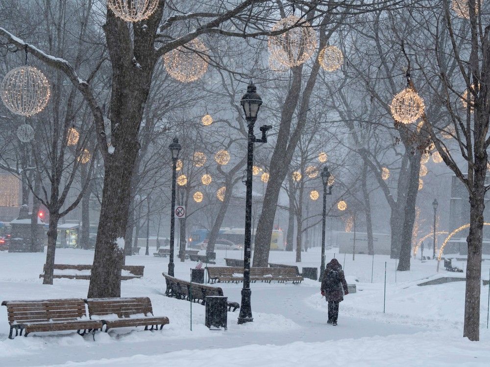 People walk in downtown Montreal on Jan. 9, 2024. Intense flurries are forecast Sunday morning, Jan. 14 for parts of the Montreal region and will likely to make visibility difficult.
