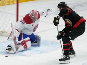 Canadiens goaltender Cayden Primeau kicks out the puck under pressure from Senators wingerZack MacEwen during action Thursday night in Ottawa.