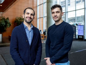 Mohsen Farhadloo and James Peters pose for a photo in the atrium of a building