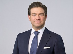 Maxime Ménard in a suit on a grey background