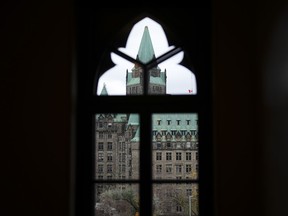 The federal inquiry into foreign interference says its initial hearings will help identify ways to make information public even though much of it will originate from classified documents and sources.The Confederation Building is pictured through a window on Parliament Hill in Ottawa on Tuesday, Nov. 7, 2023.