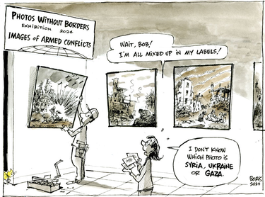 Cartoon of a man putting up photos at an exhibition entitled "Images of Armed Conflict." A woman standing behind him says "Wait, Bob! I'm all mixed up in my labels! I don't know which photo is Syria, Ukraine or Gaza."