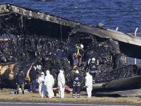 Officials investigate the wreckage of Japan Airlines plane at Haneda airport on Thursday, Jan. 4, 2024, in Tokyo, Japan.