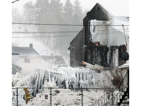 A firefighter walks through the scene of fatal fire at the Résidence du Havre seniors home in L'Isle-Verte on Jan. 24, 2014.