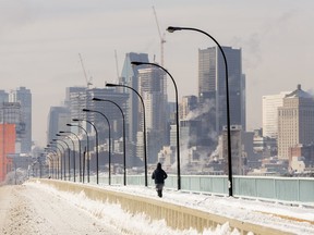 Montreal's skyline dwarfs a jogger as ice fog rises off the St. Lawrence River.