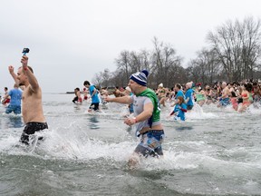 People participate in the annual New Year's Day Polar Bear Dip in Oakville, Ont., on Sunday, Jan. 1, 2023.