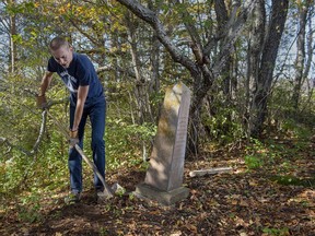 Steve Skafte, a photographer and writer based in Nova Scotia's Annapolis Valley, works to stabilize a grave marker in a small, long-abandoned cemetery in West Paradise, N.S. on Thursday, Oct. 21, 2021.