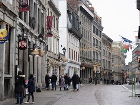 People walk on the snowless streets in Old Montreal, Wednesday, Jan. 3, 2024.