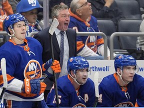 Head coach Patrick Roy, second from left, is seen screaming at somebody on the ice during his first game behind the Islanders bench in Elmont, N.Y., Sunday night.