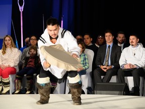 Prime Minister Justin Trudeau and Nunavut Premier P. J. Akeeagok watch a traditional drum dancer at the signing of the Nunavut devolution agreement in Iqaluit, Thursday, Jan. 18, 2024.