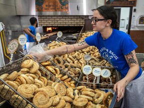 A worker at St-Viateur Bagel fills baskets with bagels, including the new hole-free version, at the shop on Tuesday.