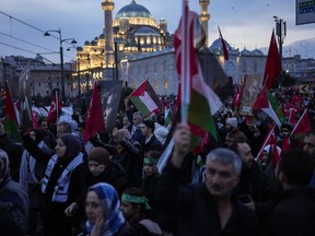 People demonstrate next to Yeni Cami (New Mosque) to show solidarity with Palestinians amid the ongoing war in Gaza, in Istanbul, Turkey, Monday, Jan. 1, 2024.