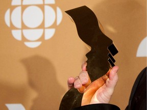 A Gémeaux award trophy is held in the air in front of a CBC logo