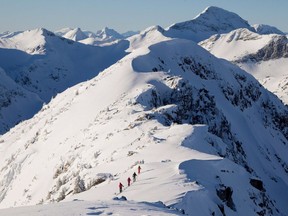 Backcountry skiers are dwarfed by the mountains.
