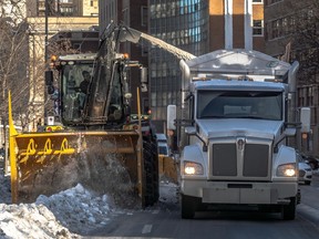 City workers race to clean up snow on Sherbrooke St. W. in Montreal on Friday, Jan. 12, 2024, ahead of a coming snowstorm.